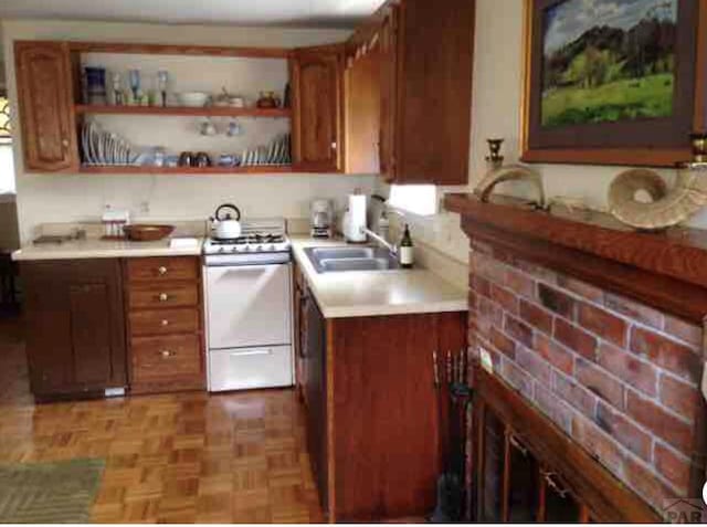 314 S Main St, La Veta, CO 81055 - kitchen with brown cabinets, open shelves, light countertops, a sink, and white range with gas stovetop