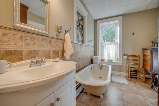 314 S Main St, La Veta, CO 81055 - bathroom featuring a paneled ceiling, wainscoting, vanity, tile patterned flooring, and a freestanding tub