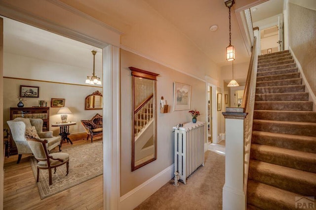 314 S Main St, La Veta, CO 81055 - stairway featuring a chandelier, radiator, baseboards, and wood finished floors