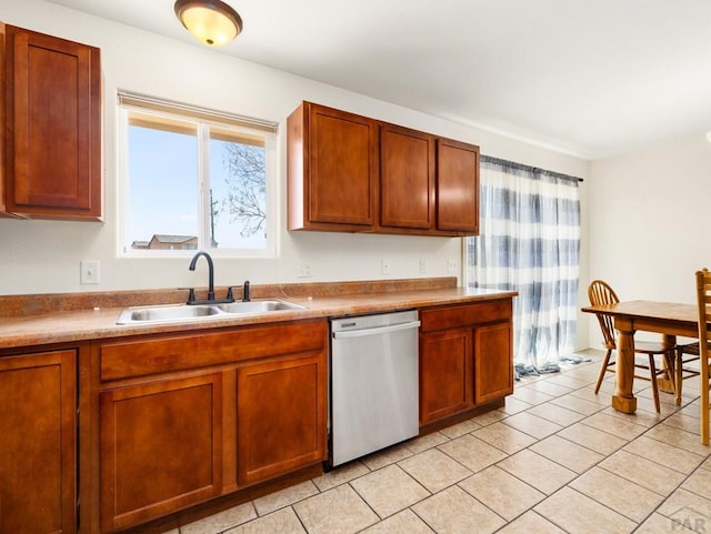 kitchen with light tile patterned floors, stainless steel dishwasher, a sink, and a wealth of natural light