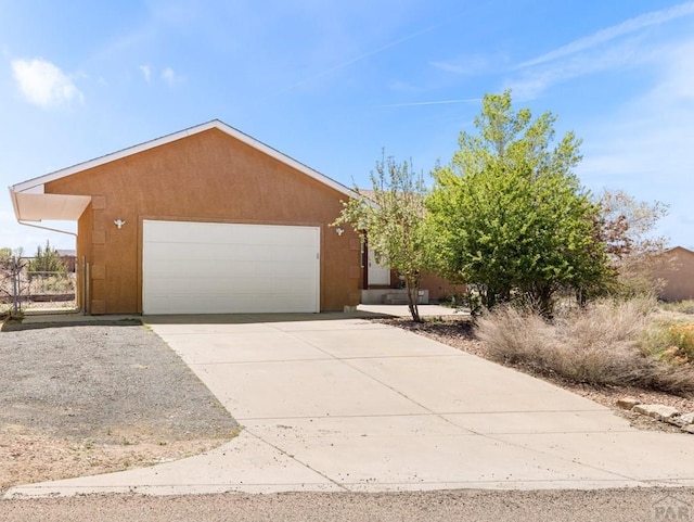view of front of house featuring stucco siding, a garage, and concrete driveway