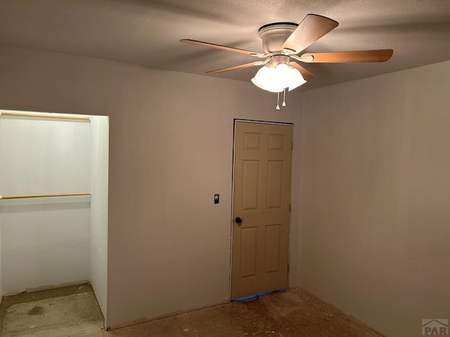 interior space with ceiling fan and unfinished concrete flooring