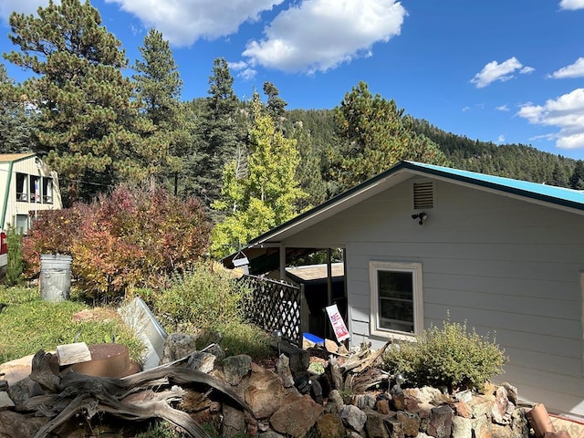 view of side of home featuring a wooded view