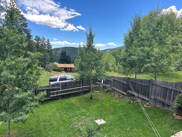 view of yard with fence and a mountain view