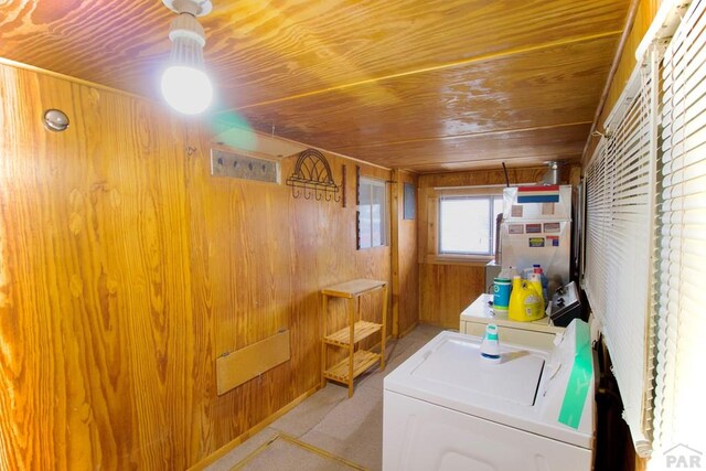 laundry room featuring wooden ceiling, laundry area, wood walls, heating unit, and washer and clothes dryer