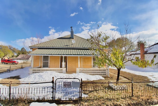 203 Santa Rita, Aguilar, CO 81020 - view of front of property featuring covered porch, metal roof, a fenced front yard, and stucco siding