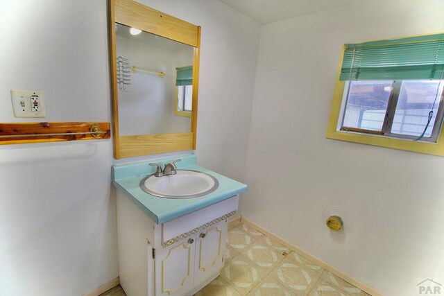 bathroom with tile patterned floors, vanity, and baseboards