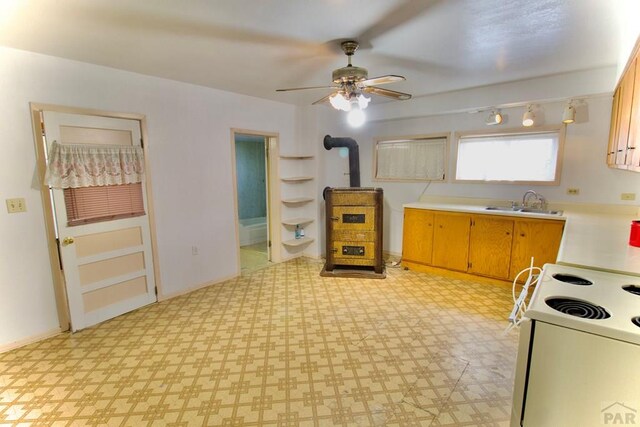 kitchen featuring white electric range oven, ceiling fan, light countertops, light floors, and a sink