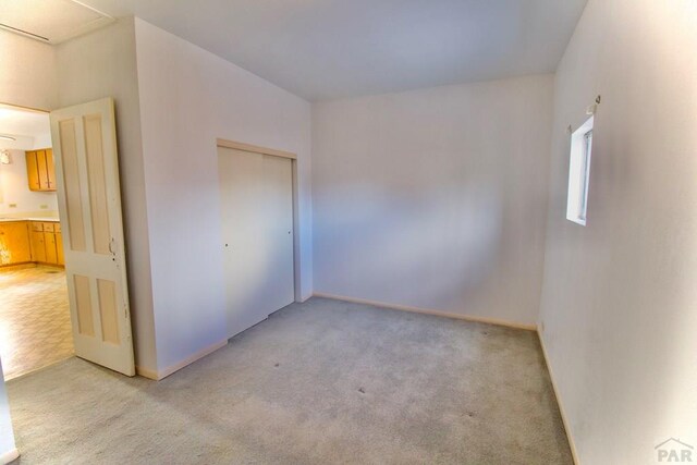 interior space with baseboards and light colored carpet