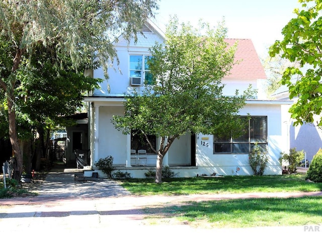 view of front facade with a front yard and stucco siding