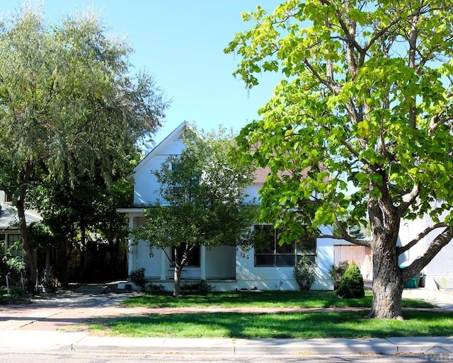 obstructed view of property featuring a front lawn