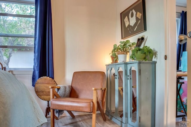 living area with light wood-style floors and a decorative wall