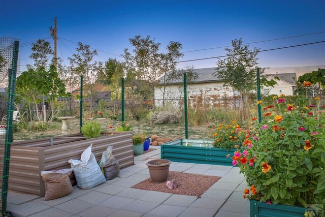 view of patio featuring a garden and fence