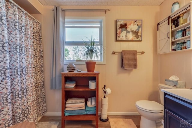 full bathroom with baseboards, vanity, toilet, and wood finished floors