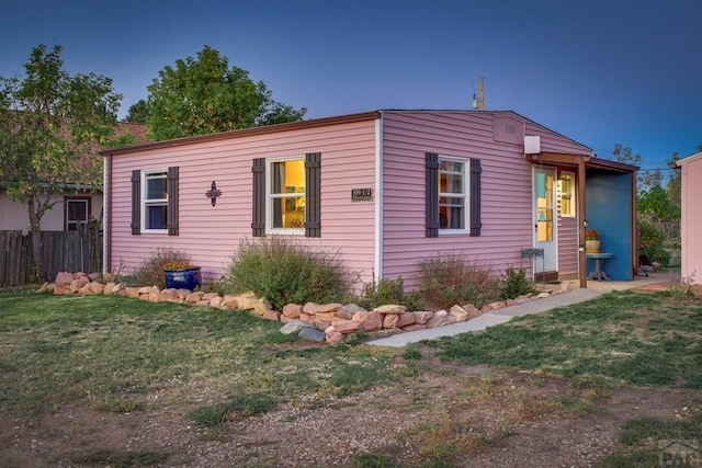 view of front of property featuring fence and a front lawn