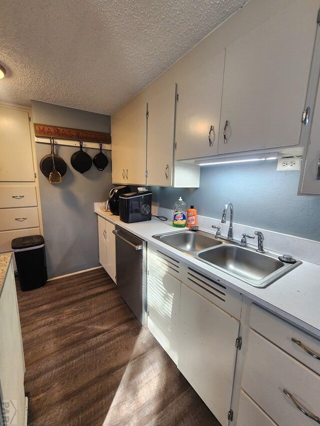 kitchen with a textured ceiling, a sink, dark wood-style floors, light countertops, and dishwasher