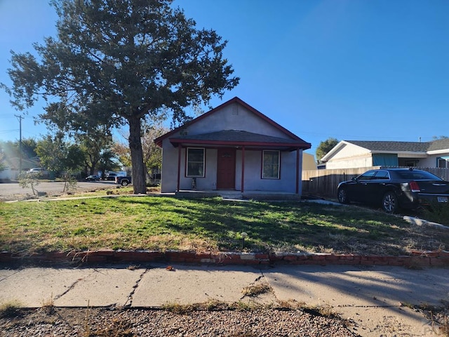 bungalow-style house featuring a front lawn and fence