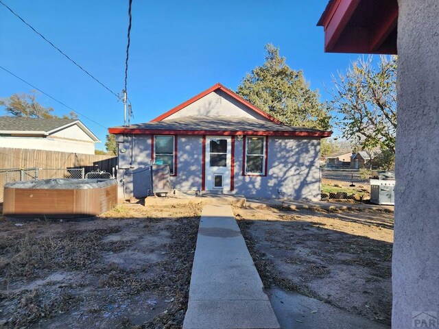 view of front of property with fence private yard and a hot tub