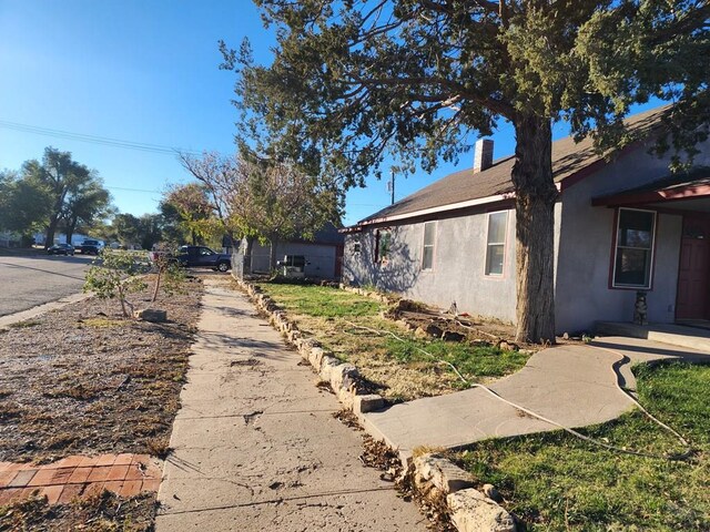 view of side of property with a chimney and stucco siding