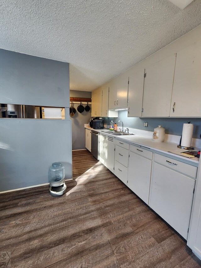 kitchen with dishwasher, light countertops, dark wood-type flooring, and white cabinets