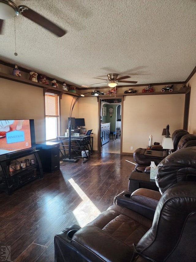 living area featuring dark wood-style floors, ceiling fan, and a textured ceiling