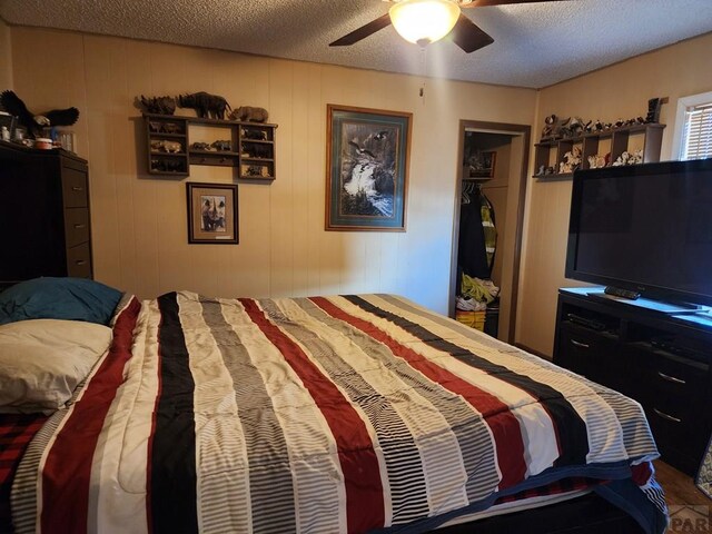 bedroom featuring ceiling fan and a textured ceiling