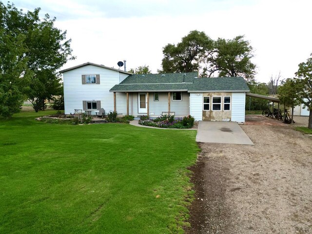 view of front of house with a carport, a front lawn, and driveway