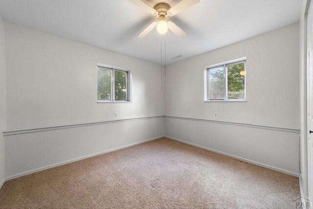 unfurnished room featuring visible vents, carpet flooring, a wealth of natural light, and baseboards