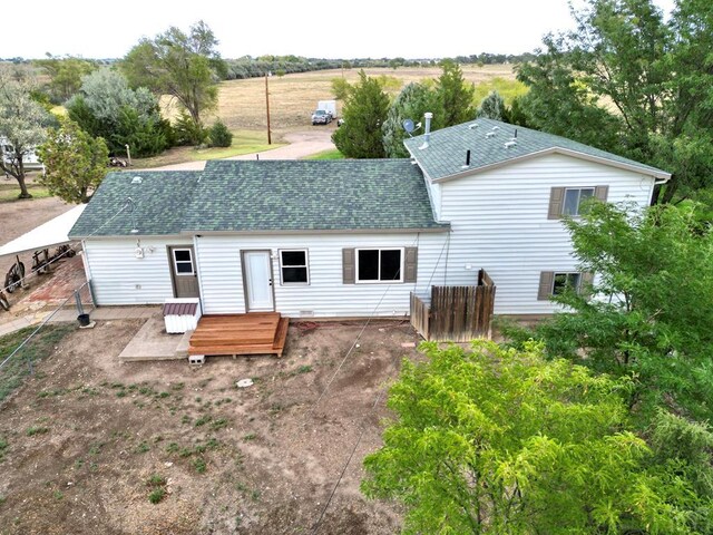 back of property featuring roof with shingles