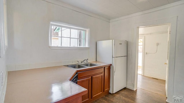 509 Walsen Ave, Walsenburg, CO 81089 - kitchen with a sink, freestanding refrigerator, brown cabinetry, and a wealth of natural light