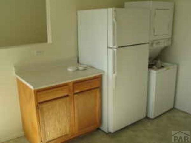 kitchen with light countertops and freestanding refrigerator