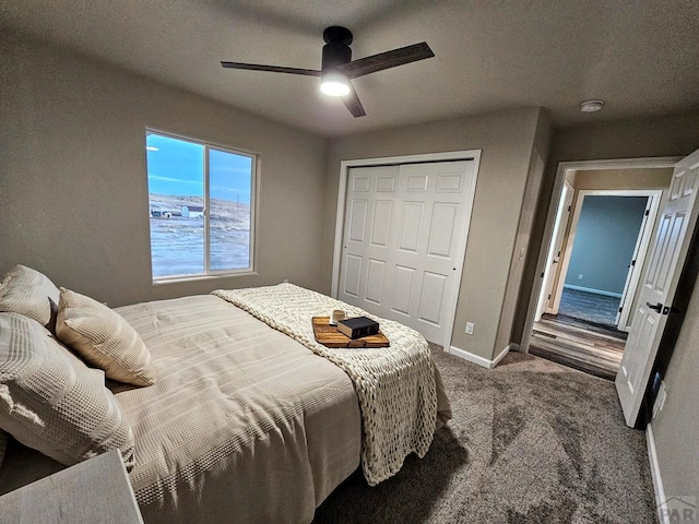 bedroom featuring ceiling fan, dark colored carpet, a closet, and baseboards