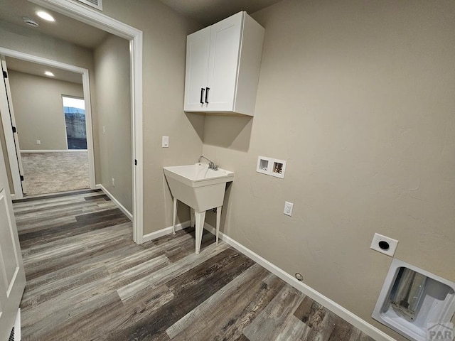 laundry room with washer hookup, wood finished floors, cabinet space, and electric dryer hookup