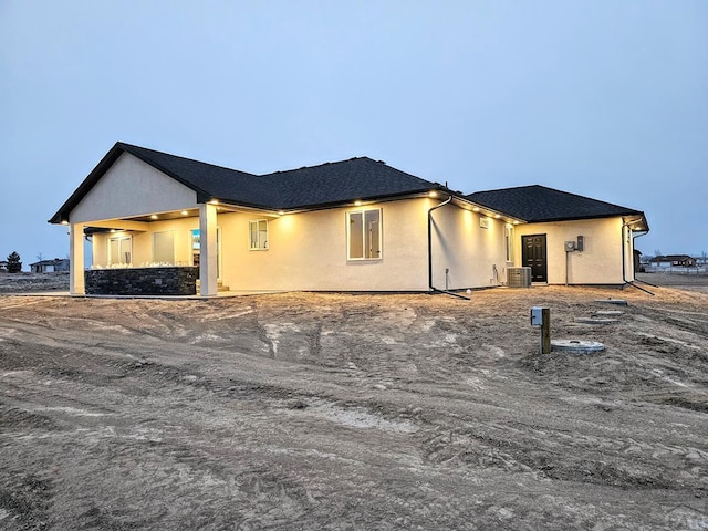 exterior space with stucco siding and central air condition unit