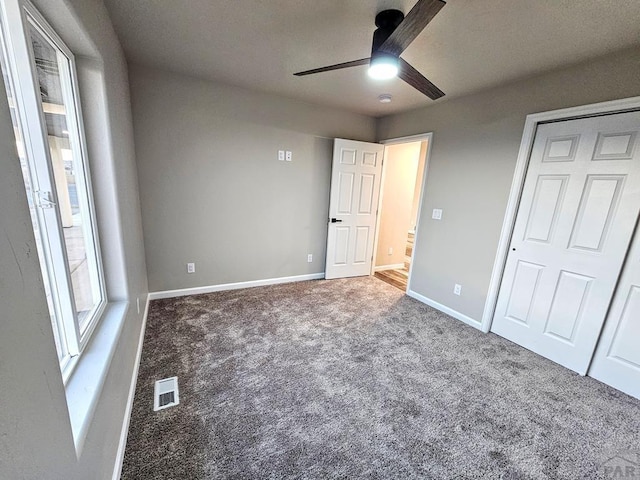 unfurnished bedroom featuring a ceiling fan, baseboards, visible vents, and carpet flooring