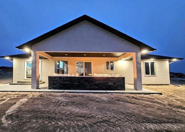 back of house with a patio and stucco siding