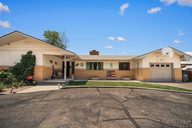 67 Macarthur Rd, Pueblo, CO 81001 - single story home featuring an attached garage, brick siding, a chimney, and driveway