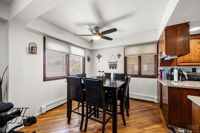 67 Macarthur Rd, Pueblo, CO 81001 - dining area with ceiling fan, a baseboard radiator, and dark wood-type flooring