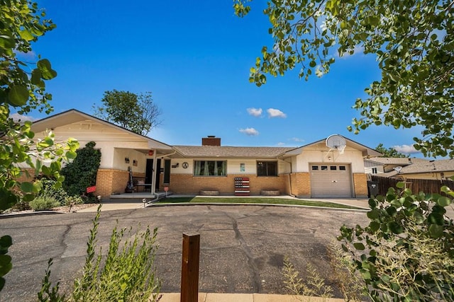 67 Macarthur Rd, Pueblo, CO 81001 - single story home featuring brick siding, a garage, a chimney, and driveway