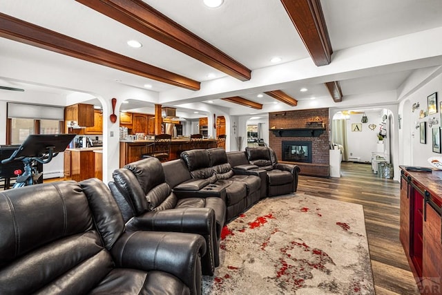 67 Macarthur Rd, Pueblo, CO 81001 - living area with arched walkways, dark wood-style flooring, recessed lighting, a fireplace, and beam ceiling