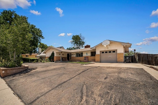 67 Macarthur Rd, Pueblo, CO 81001 - single story home featuring brick siding, a garage, concrete driveway, and a chimney