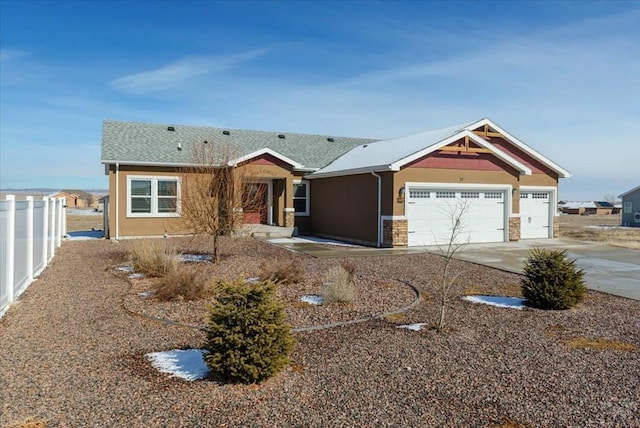 view of front of home featuring an attached garage, fence, concrete driveway, stone siding, and stucco siding