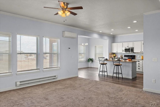 kitchen featuring stainless steel microwave, a wall mounted air conditioner, baseboard heating, a kitchen bar, and white cabinetry