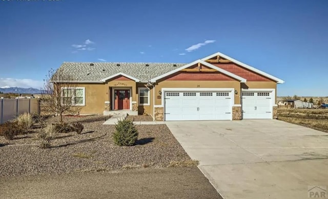 craftsman house with a garage, concrete driveway, and stucco siding