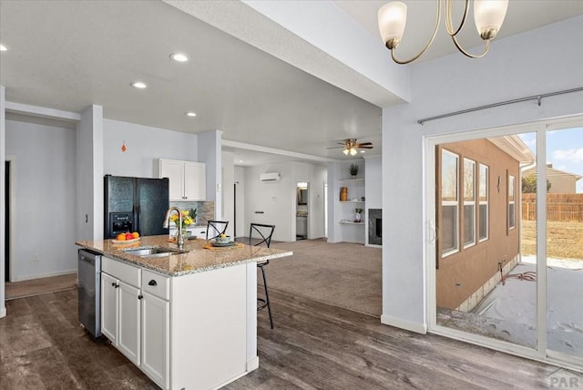 kitchen featuring light stone counters, a center island with sink, black refrigerator with ice dispenser, white cabinets, and dishwasher