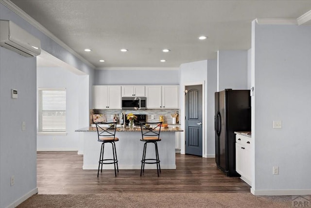 kitchen with a wall unit AC, a breakfast bar area, stainless steel microwave, light stone counters, and white cabinetry