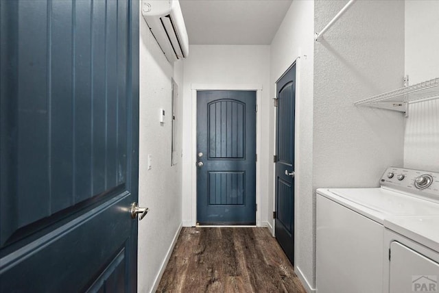 clothes washing area featuring laundry area, separate washer and dryer, dark wood-type flooring, baseboards, and a wall mounted AC