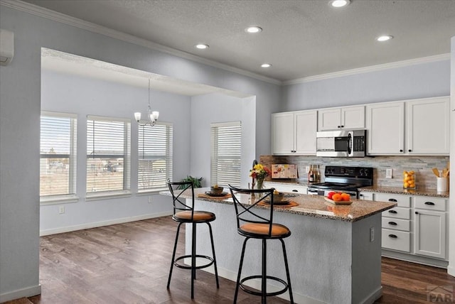 kitchen featuring range with electric cooktop, white cabinetry, light stone countertops, tasteful backsplash, and stainless steel microwave