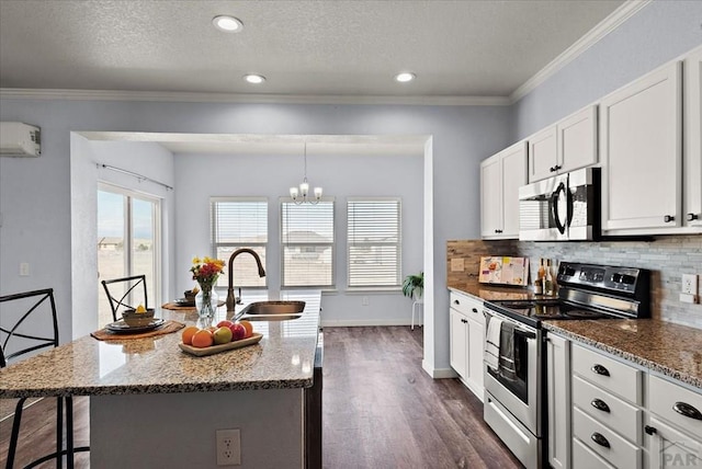 kitchen with stainless steel appliances, light stone counters, a sink, and a center island with sink