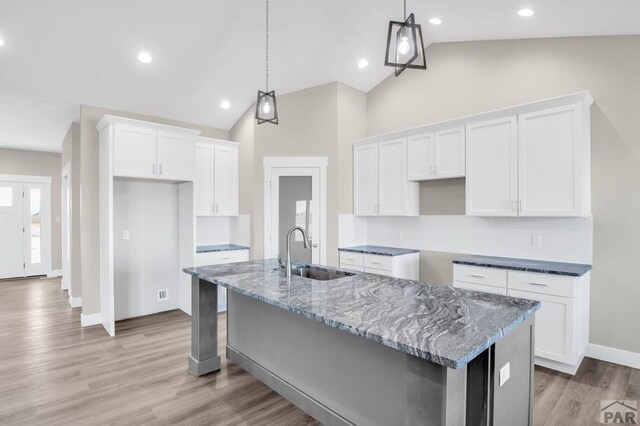 kitchen with a sink, a kitchen island with sink, and pendant lighting